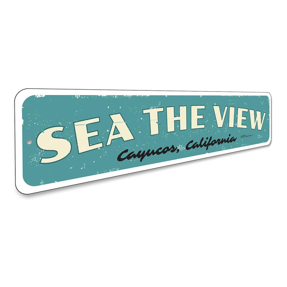 A decorative Sea The View Sign made of high-quality aluminum, featuring a beach-themed design, perfect for coastal decor.