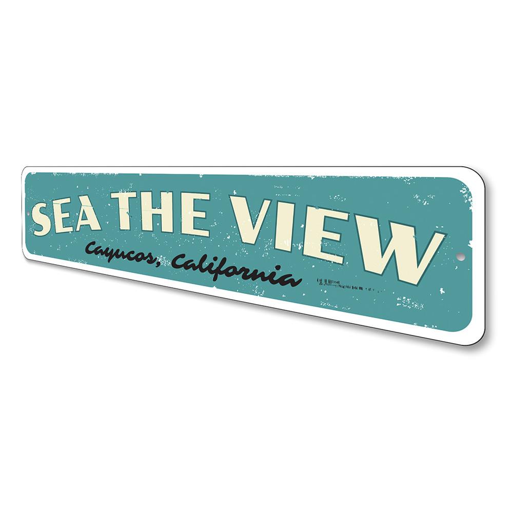 A decorative Sea The View Sign made of high-quality aluminum, featuring a beach-themed design, perfect for coastal decor.