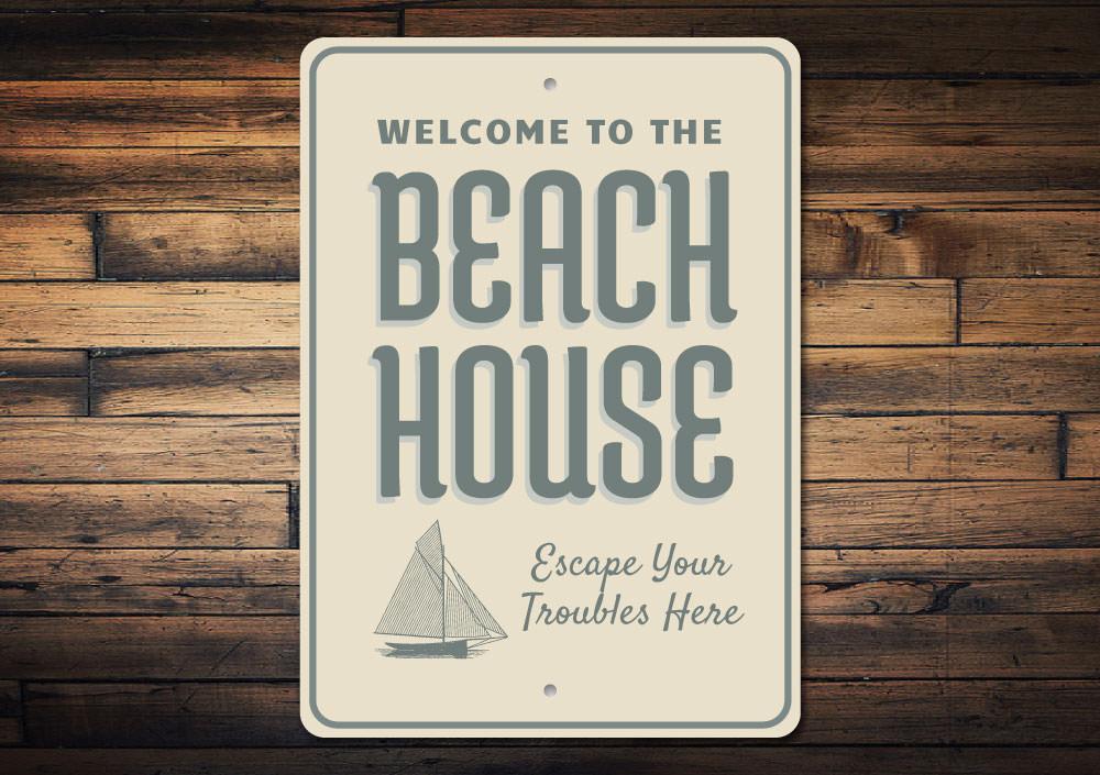 A decorative Seaside Beach House Sign made of high-quality aluminum, featuring a coastal design perfect for beach lovers.