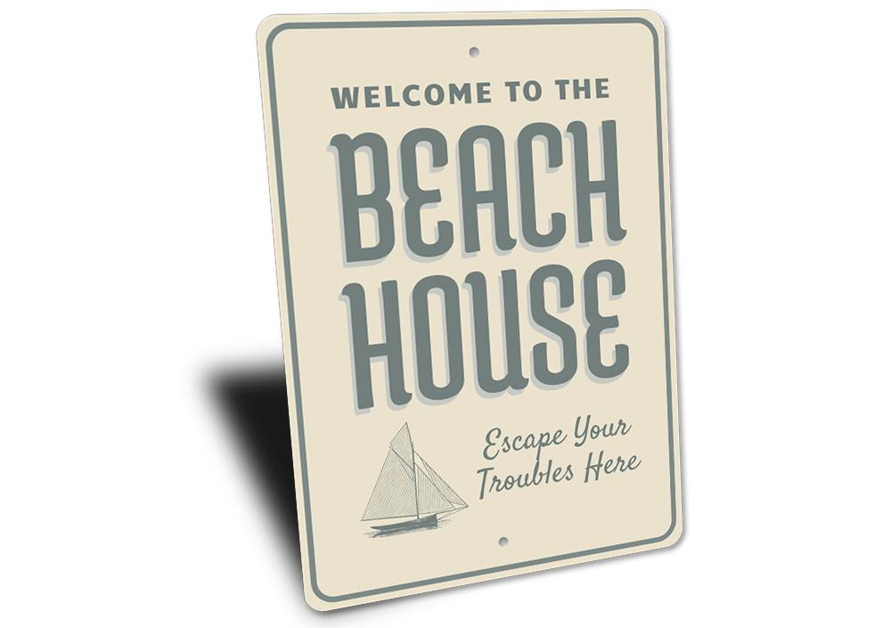 A decorative Seaside Beach House Sign made of high-quality aluminum, featuring a coastal design perfect for beach lovers.