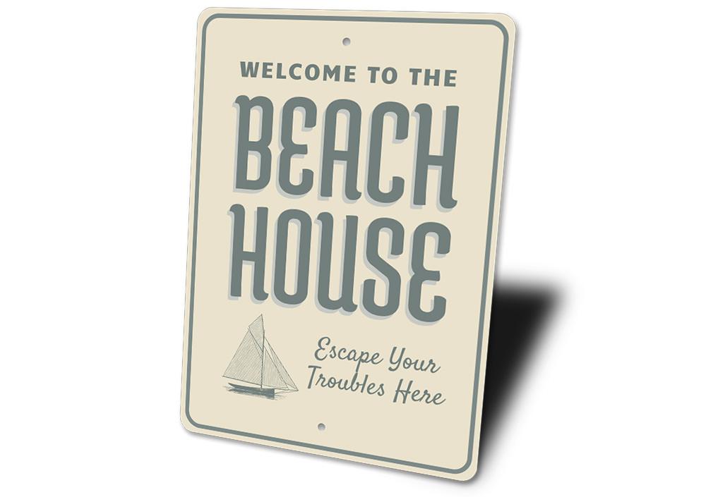 A decorative Seaside Beach House Sign made of high-quality aluminum, featuring a coastal design perfect for beach lovers.