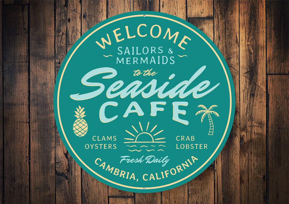 A beautifully crafted Seaside Cafe Sign made of high-quality aluminum, featuring vibrant colors and a charming coastal design, perfect for home decor.