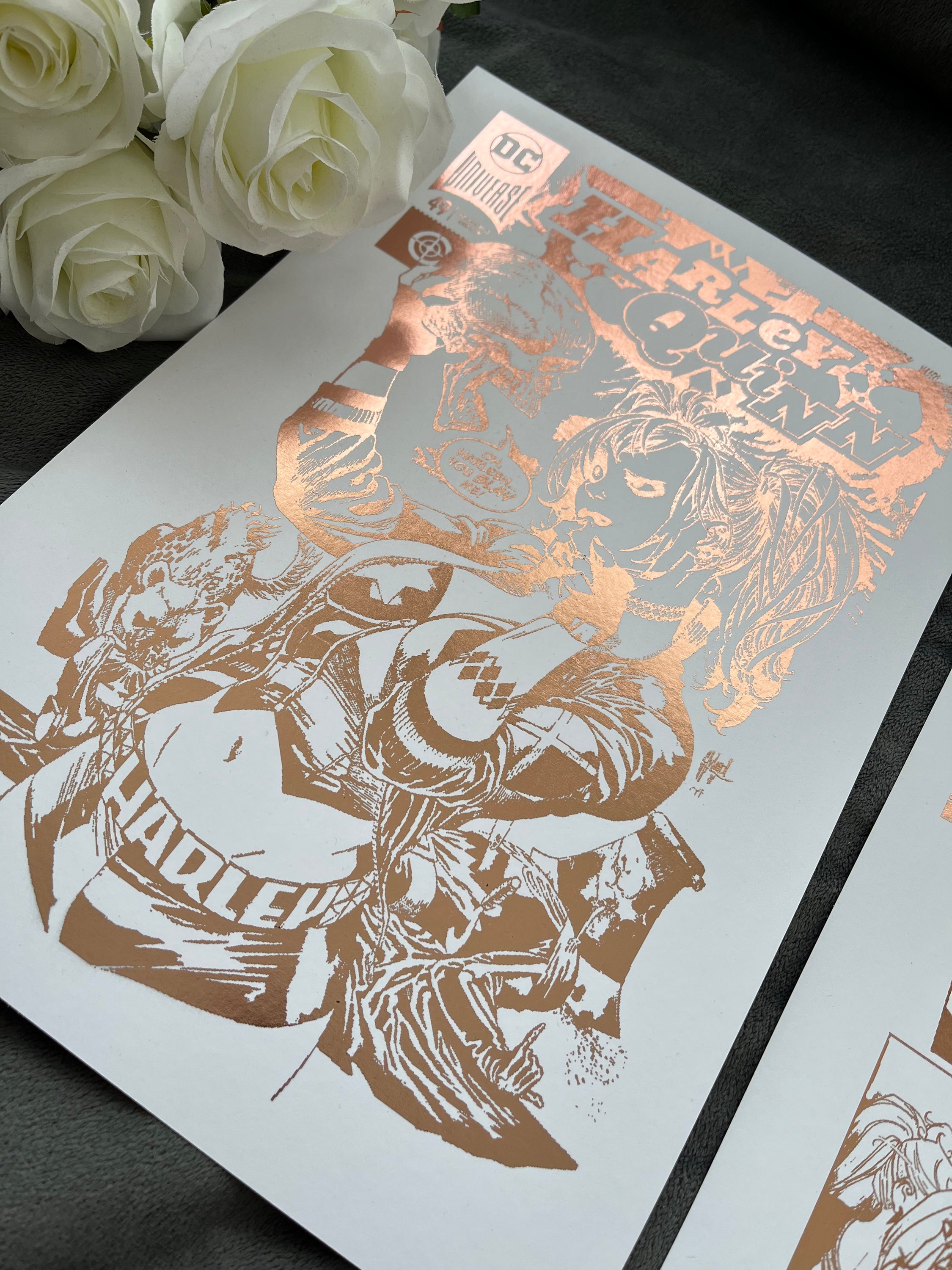 Set of 2 Harley Quinn foil prints featuring rose gold accents, showcasing a comic cover and an action-packed comic strip.