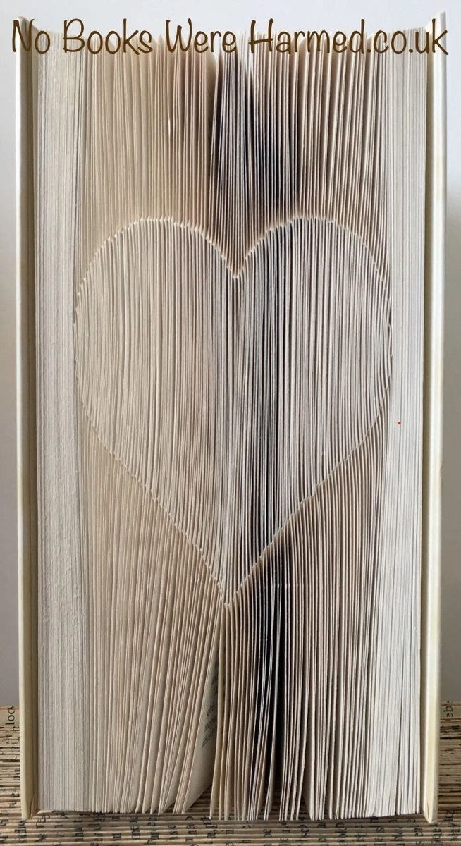 A handcrafted Shadow Love Heart made from vintage book pages, showcasing intricate folds and unique design.