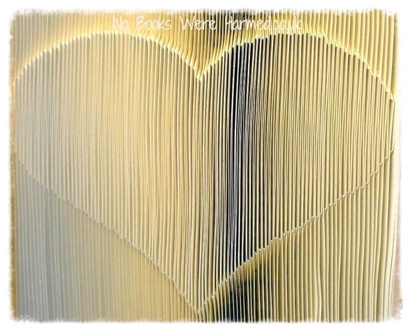 A handcrafted Shadow Love Heart made from vintage book pages, showcasing intricate folds and unique design.