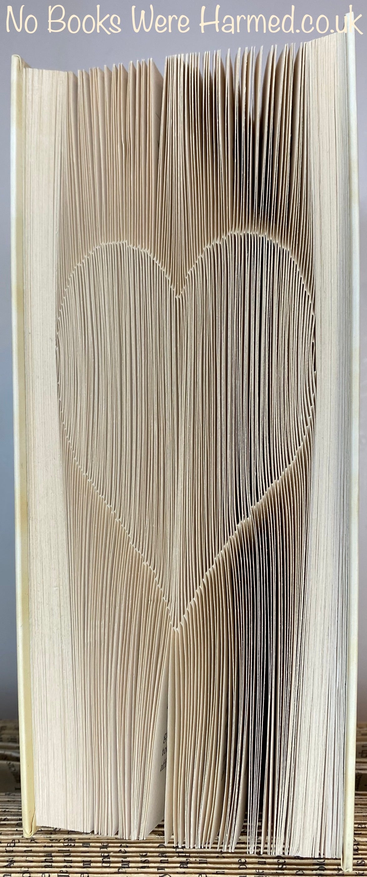 A handcrafted Shadow Love Heart made from vintage book pages, showcasing intricate folds and unique design.