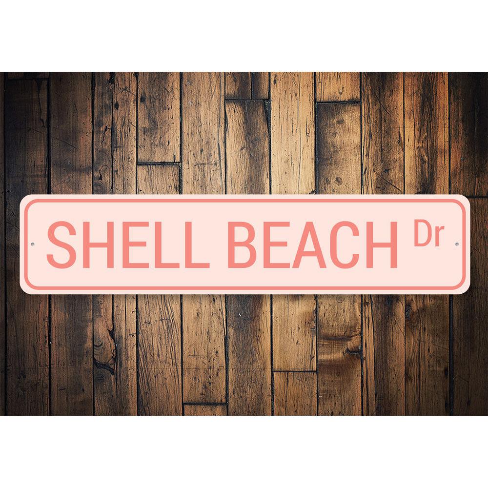 A decorative Shell Beach Drive Sign made of high-quality aluminum, featuring a coastal design perfect for beach houses and outdoor decor.