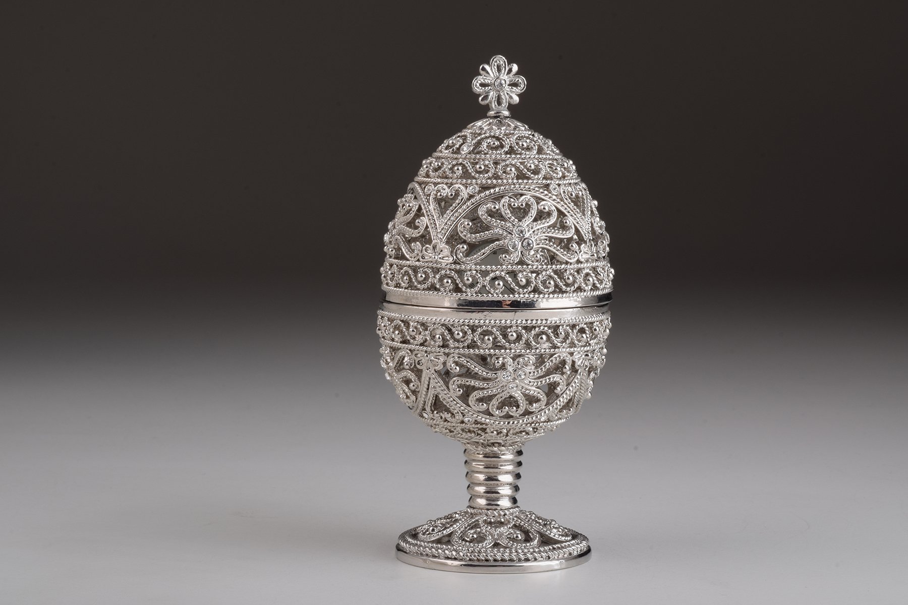 A beautifully crafted Silver Faberge Egg trinket box with a clock inside, adorned with Austrian crystals and plated in 24K Gold or 925 Silver.