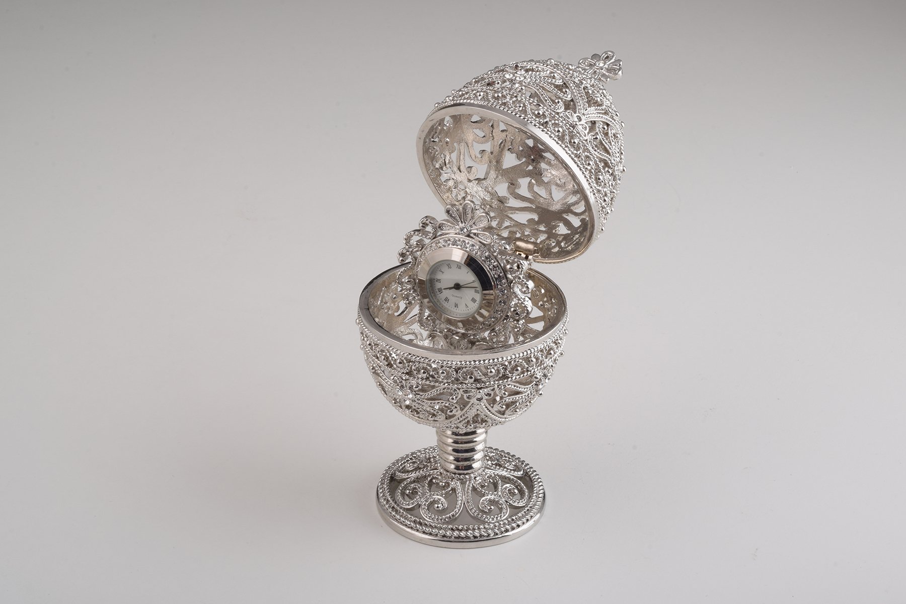 A beautifully crafted Silver Faberge Egg trinket box with a clock inside, adorned with Austrian crystals and plated in 24K Gold or 925 Silver.