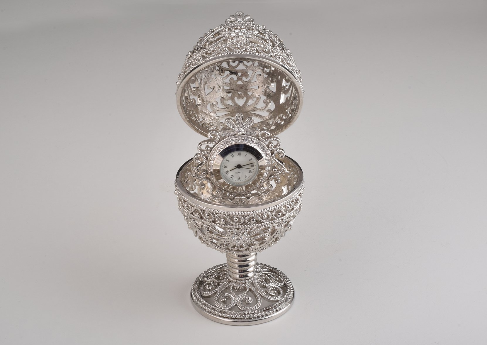 A beautifully crafted Silver Faberge Egg trinket box with a clock inside, adorned with Austrian crystals and plated in 24K Gold or 925 Silver.