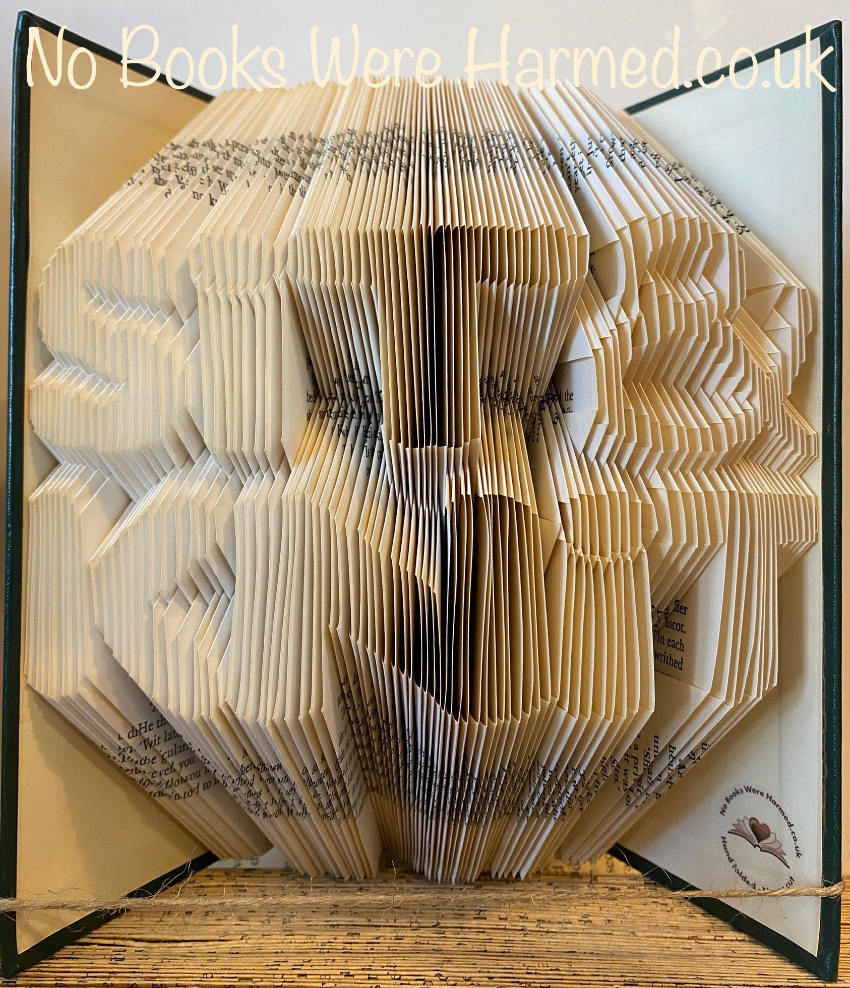 A beautifully crafted piece of book art made from hand-folded pages of a vintage book, showcasing intricate designs and unique colors.