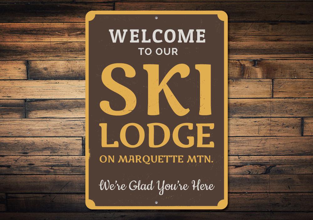 A decorative Ski Lodge Welcome Sign made of high-quality aluminum, featuring customizable text and pre-drilled holes for easy mounting.