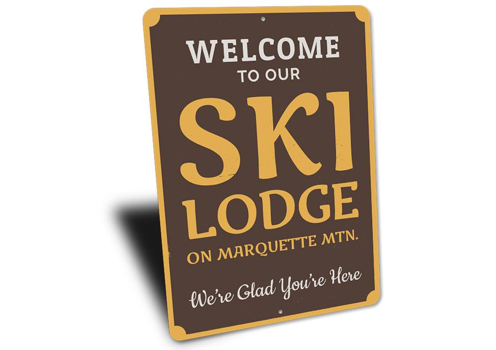 A decorative Ski Lodge Welcome Sign made of high-quality aluminum, featuring customizable text and pre-drilled holes for easy mounting.