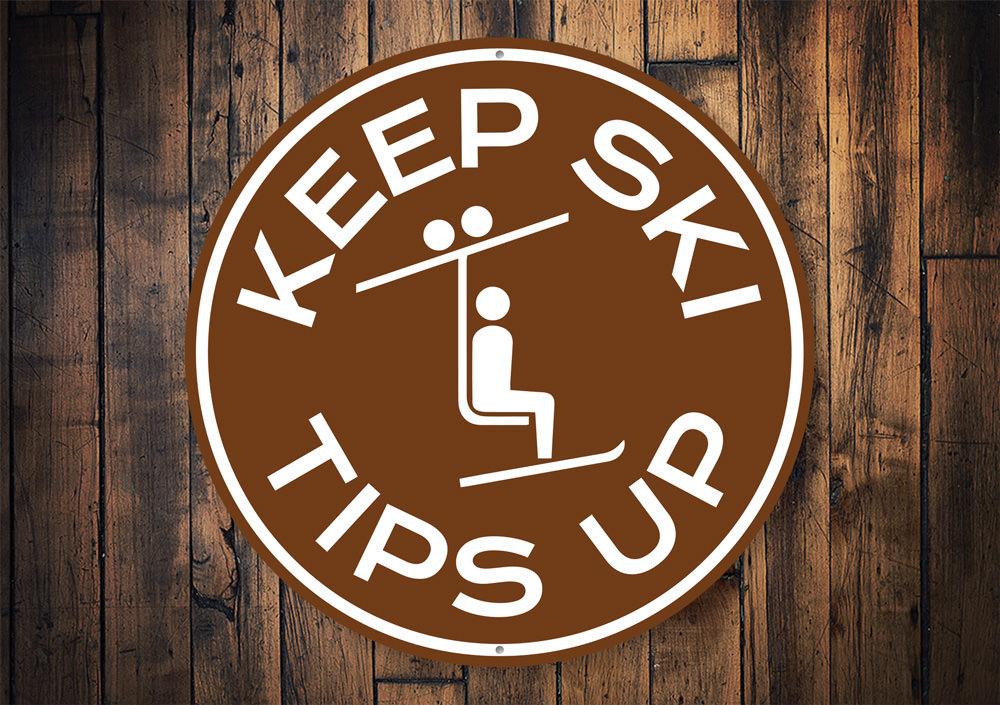 Ski Tips Up Circle Sign made of durable aluminum, featuring a ski-themed design perfect for lodge decor.