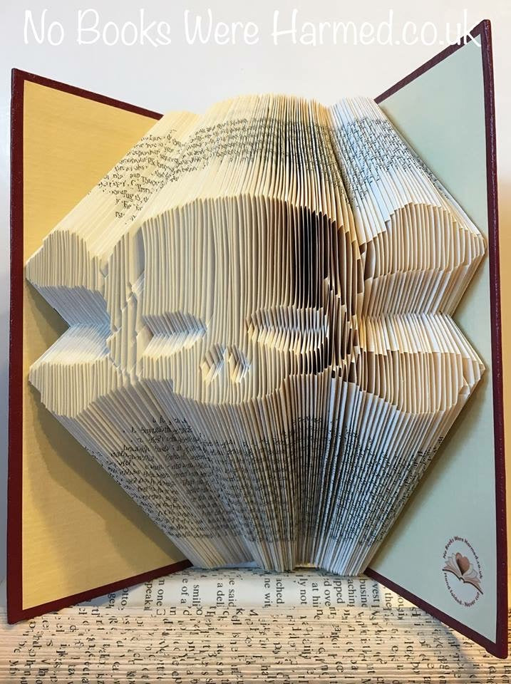 Hand-folded Skull & Crossbones art made from vintage book pages, showcasing intricate designs and unique colors.