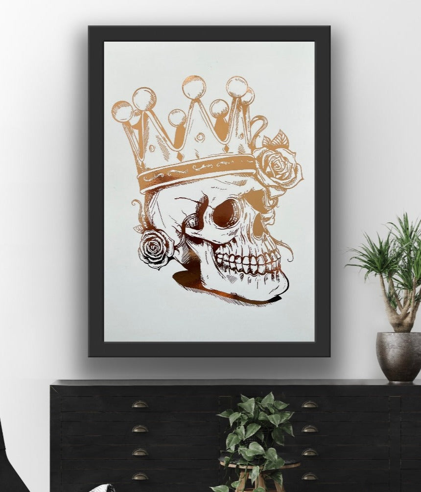 A striking rose gold foil print featuring a skull adorned with a majestic crown, showcasing intricate details and luxurious accents.