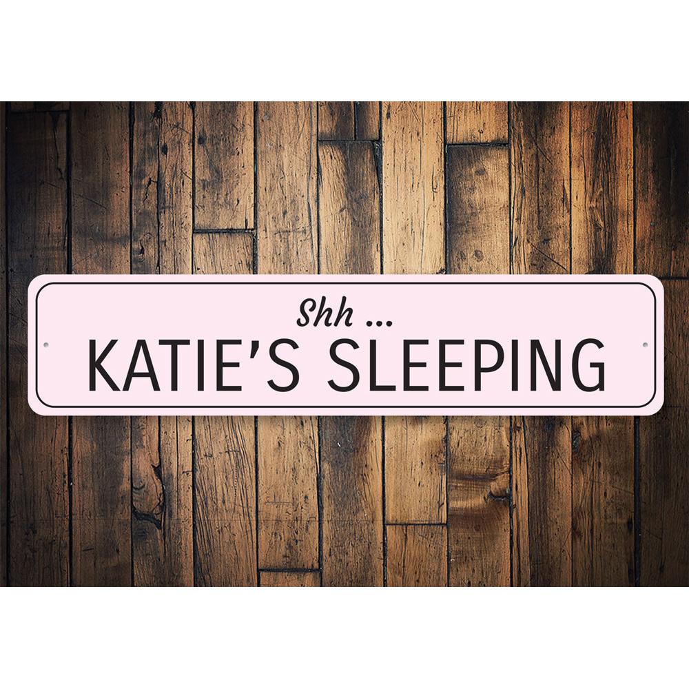 A decorative Sleeping Baby Sign made of high-quality aluminum, featuring customizable text for a child's room.