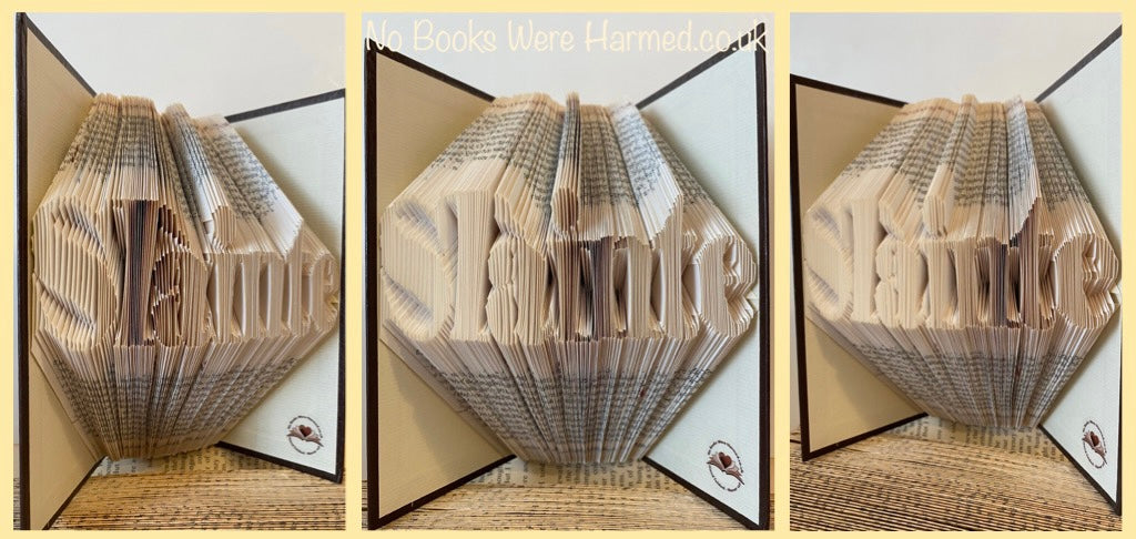 Hand folded book art piece titled 'Slàinte', showcasing intricate page folds and vintage book aesthetics, symbolizing good health.