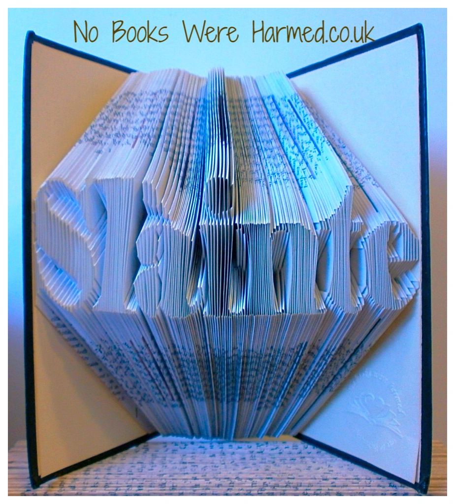 Hand folded book art piece titled 'Slàinte', showcasing intricate page folds and vintage book aesthetics, symbolizing good health.