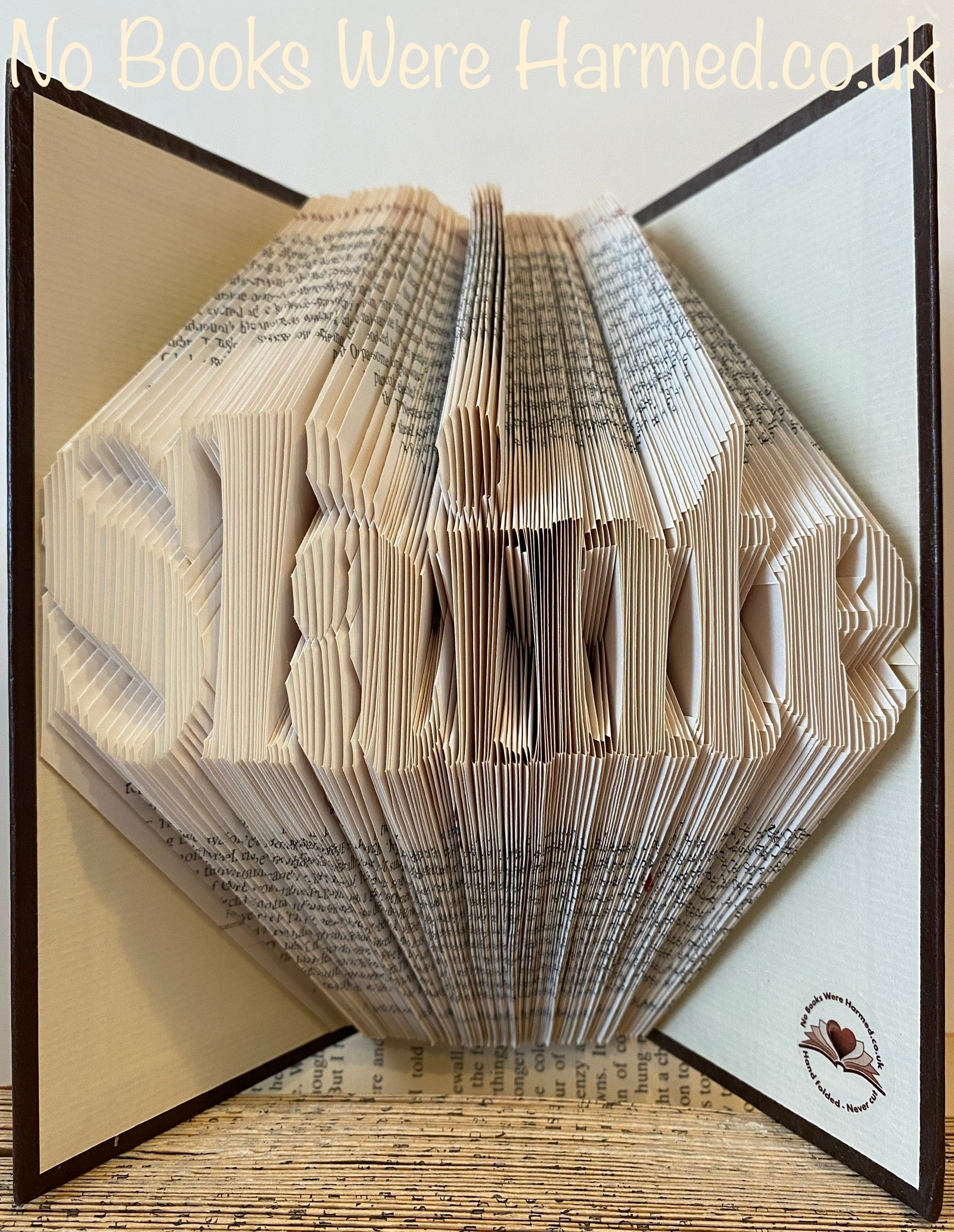 Hand folded book art piece titled 'Slàinte', showcasing intricate page folds and vintage book aesthetics, symbolizing good health.