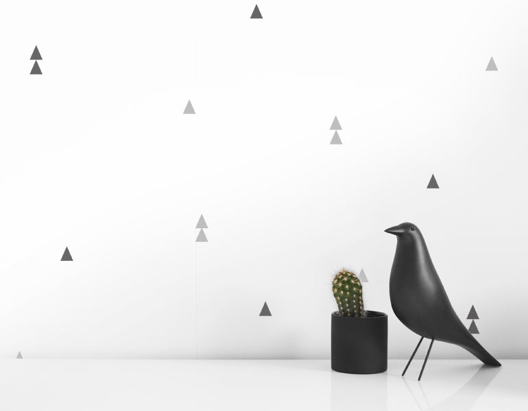 A collection of small triangle wall decals in black and gray, perfect for modern nursery and home decor.