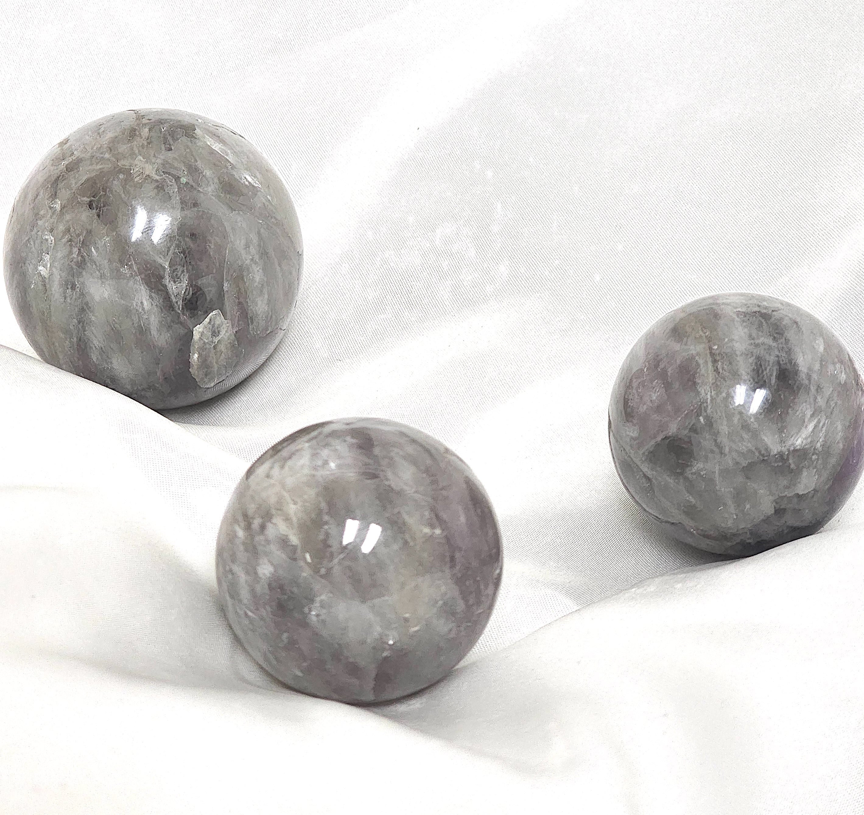 A beautifully hand-carved Smoky Amethyst Sphere showcasing the unique blend of smoky quartz and amethyst colors, perfect for healing and meditation.