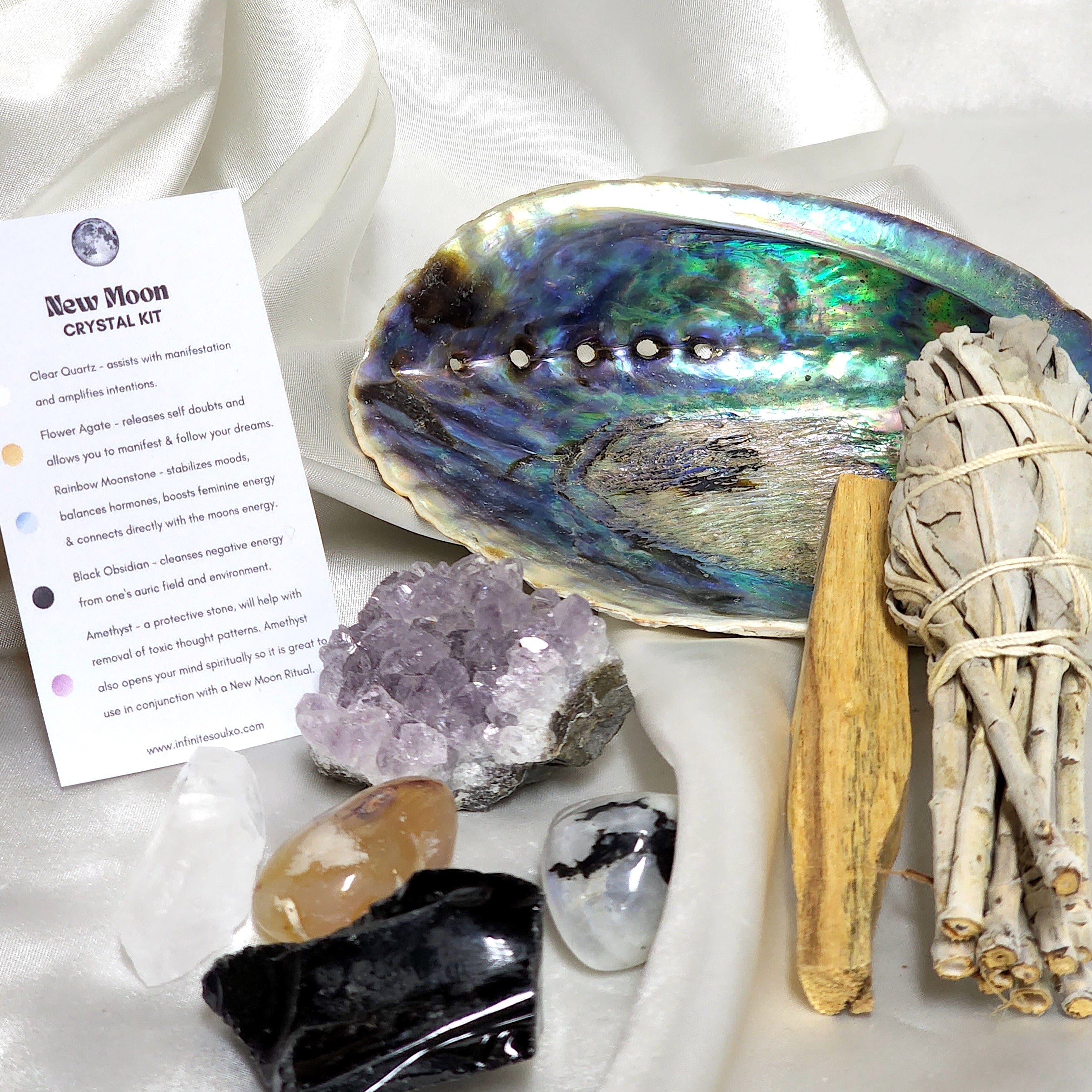 Smudge Kit: New Moon Kit featuring sage smudge stick, Palo Santo, abalone shell, and various healing crystals.