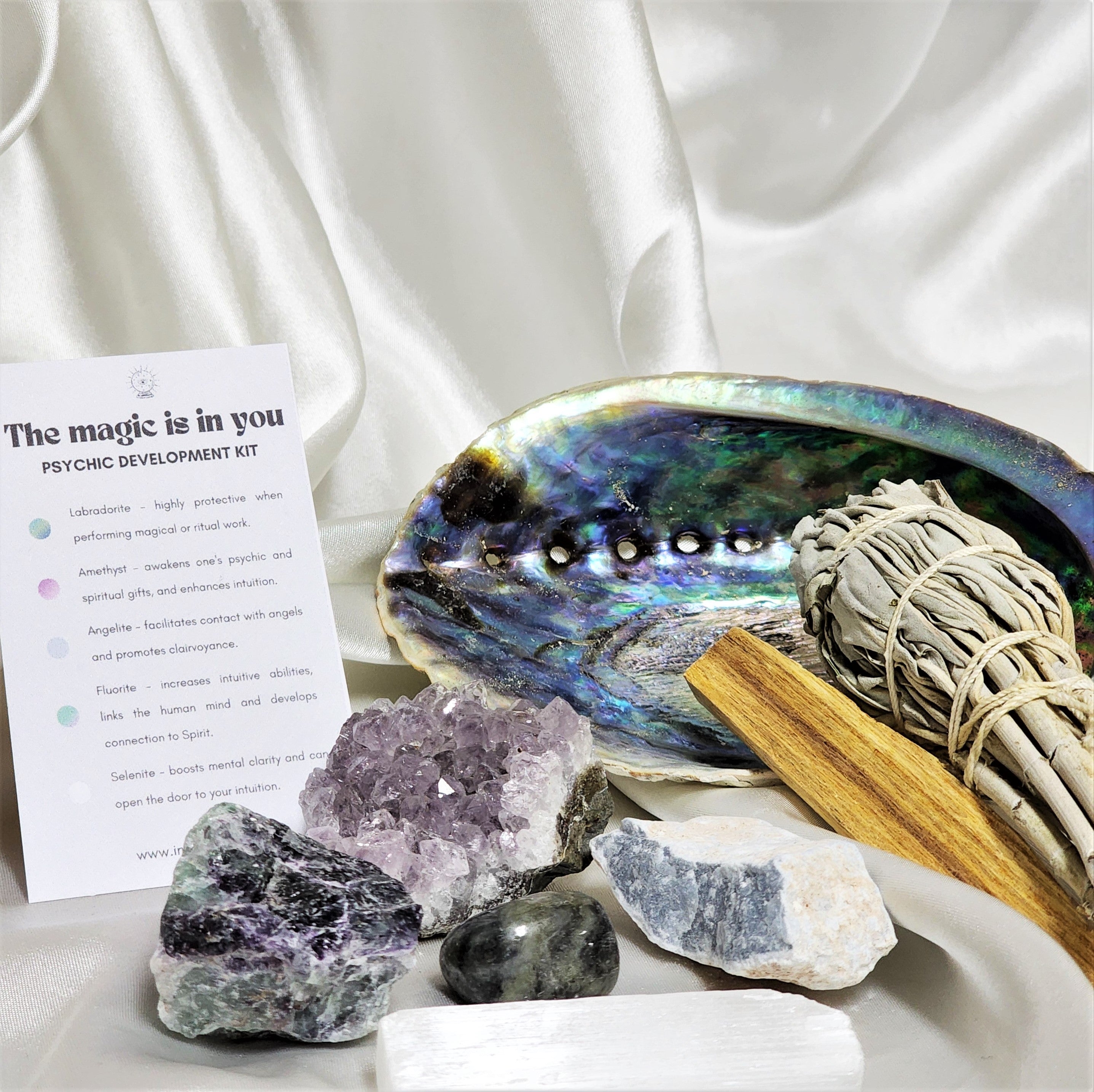 Intuition Smudge Kit featuring sage, Palo Santo, abalone shell, and various crystals for spiritual cleansing and energy balancing.