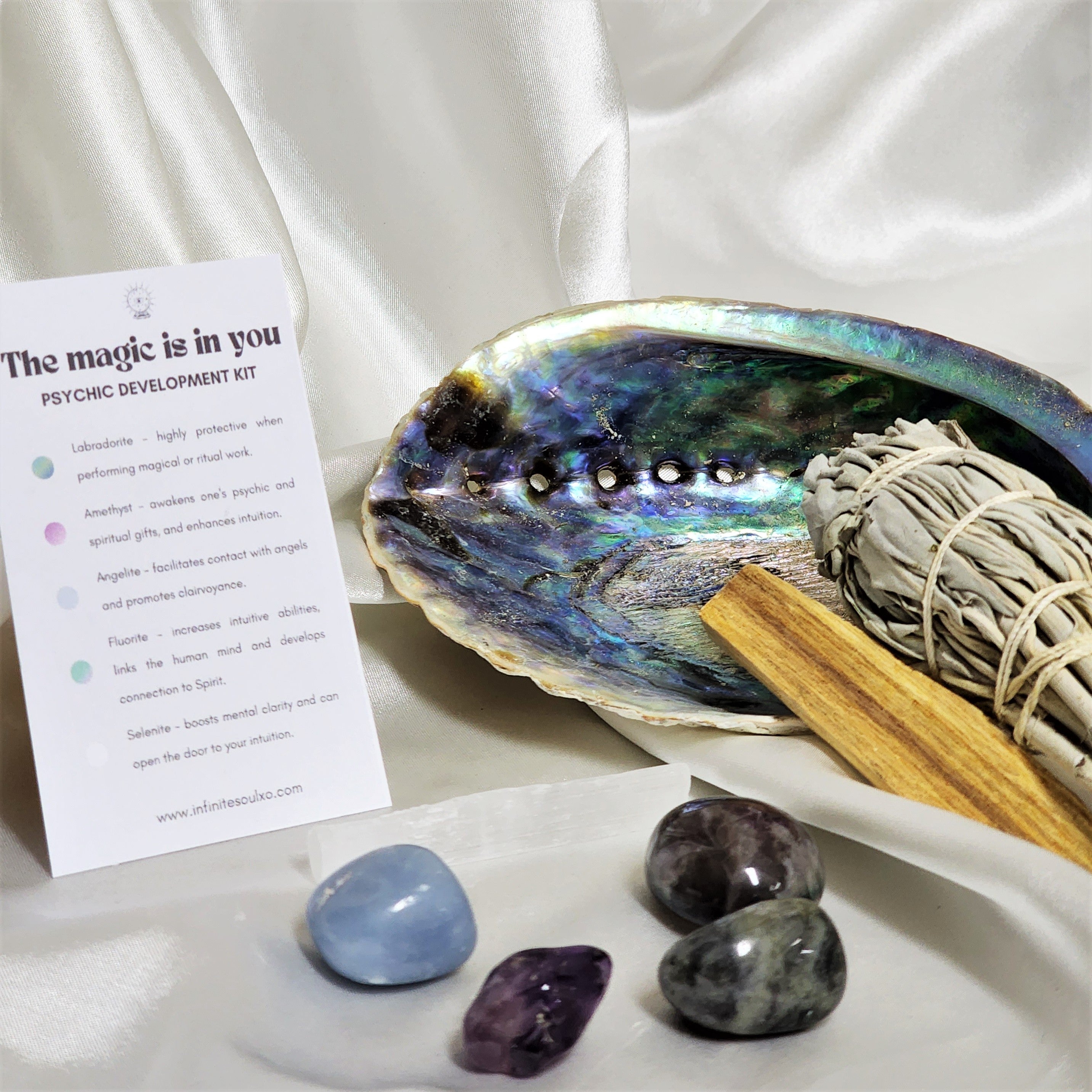 Intuition Smudge Kit featuring sage, Palo Santo, abalone shell, and various crystals for spiritual cleansing and energy balancing.