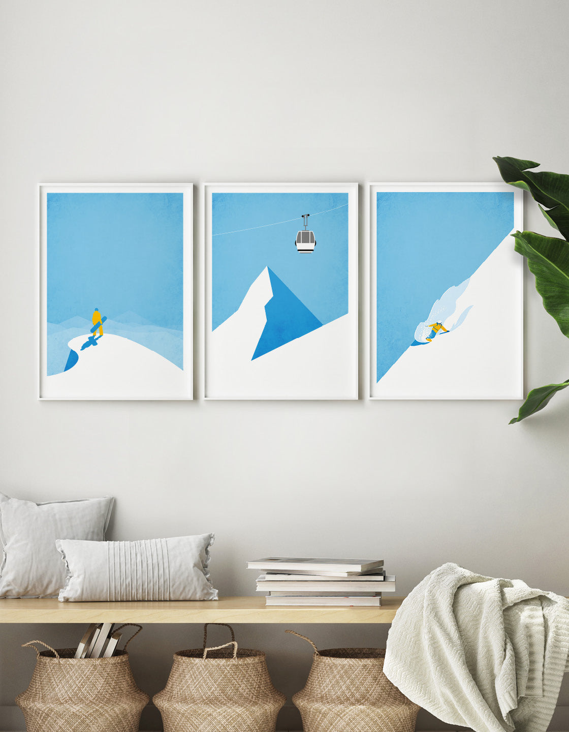 A minimalist art set of 3 posters featuring a snowboarder on a peak, a ski gondola against a blue sky, and a boarder riding powder on a mountainside.