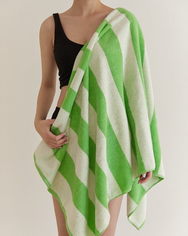 Soft and absorbent stripe bath towel made from 100% organic combed cotton, featuring a trendy green stripe design.