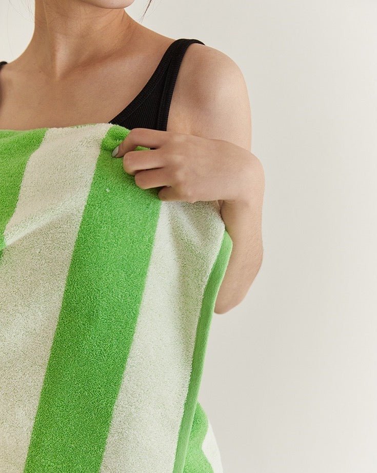 Soft and absorbent stripe bath towel made from 100% organic combed cotton, featuring a trendy green stripe design.