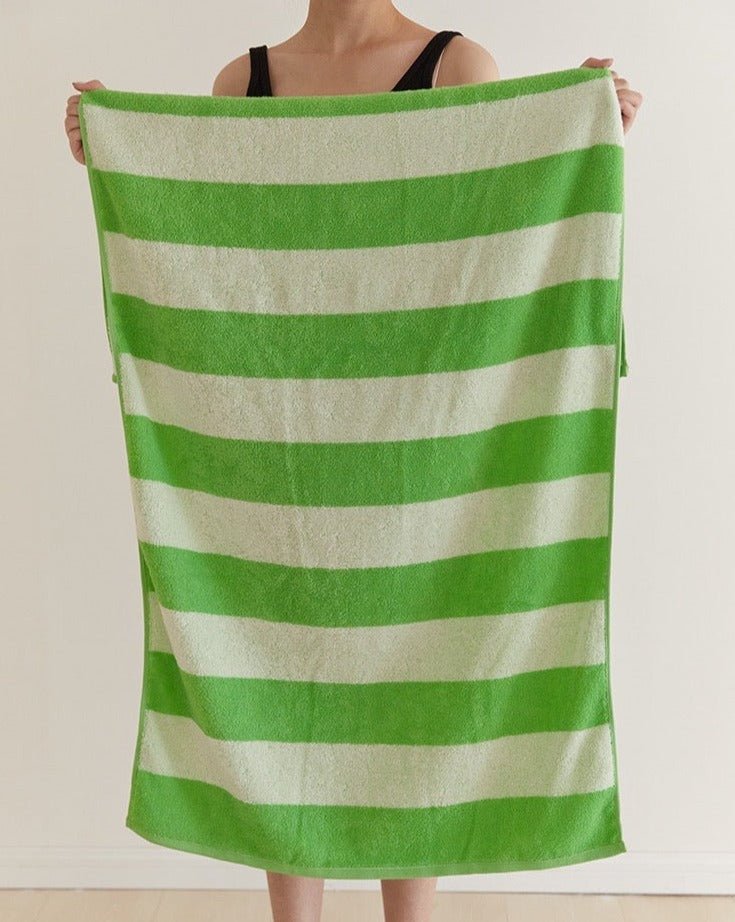 Soft and absorbent stripe bath towel made from 100% organic combed cotton, featuring a trendy green stripe design.