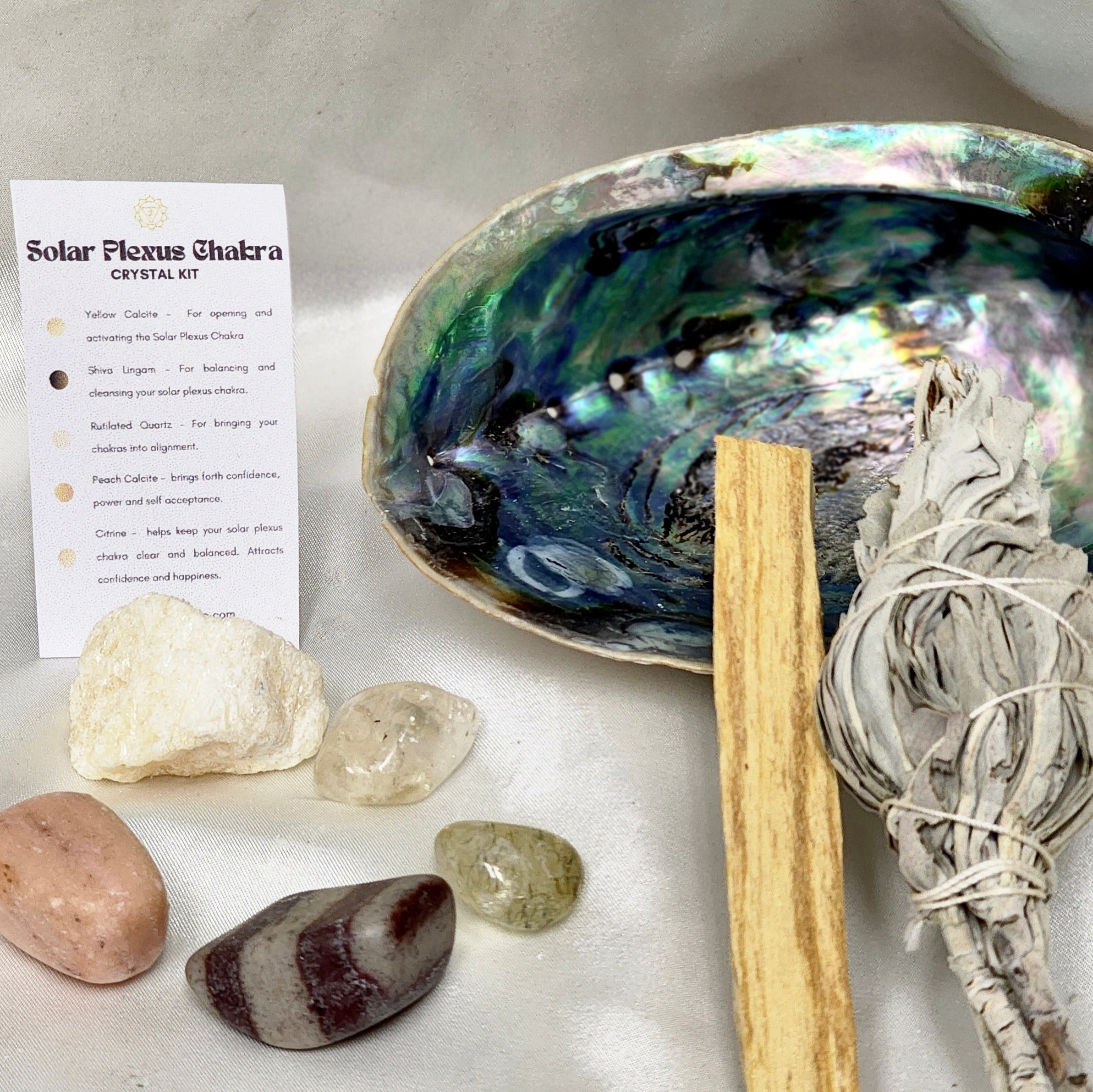 Solar Plexus Chakra Smudge Kit featuring sage smudge stick, Palo Santo, abalone shell, and various healing crystals.