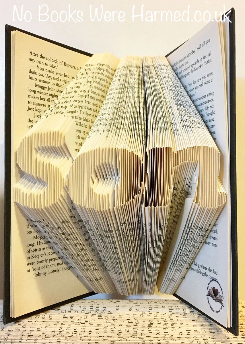 Hand-folded book art piece made from vintage books, showcasing intricate designs and unique colors.