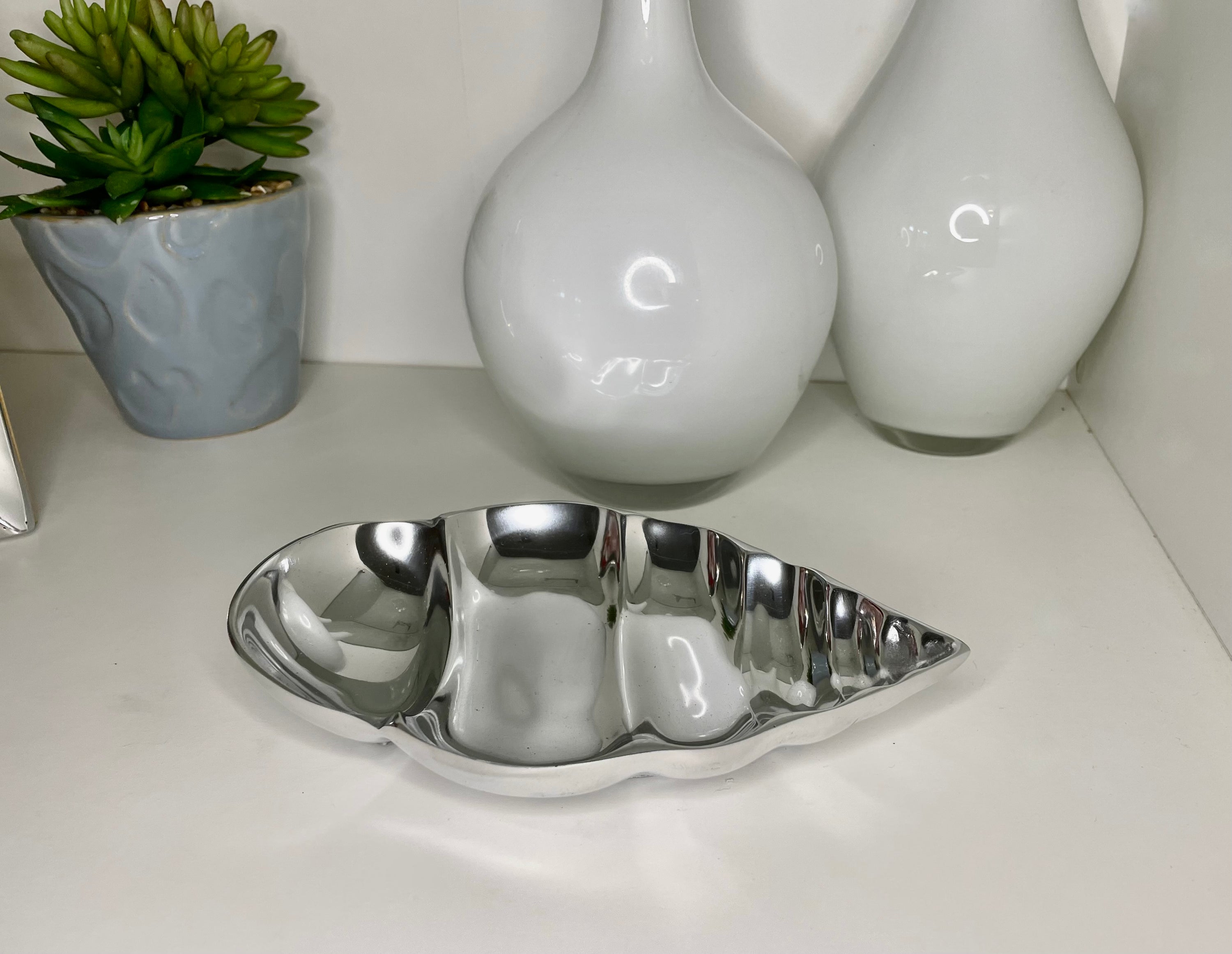 A stylish spiral-shaped snack bowl made from recycled aluminum, showcasing a unique wavy design perfect for serving snacks or as a decorative piece.