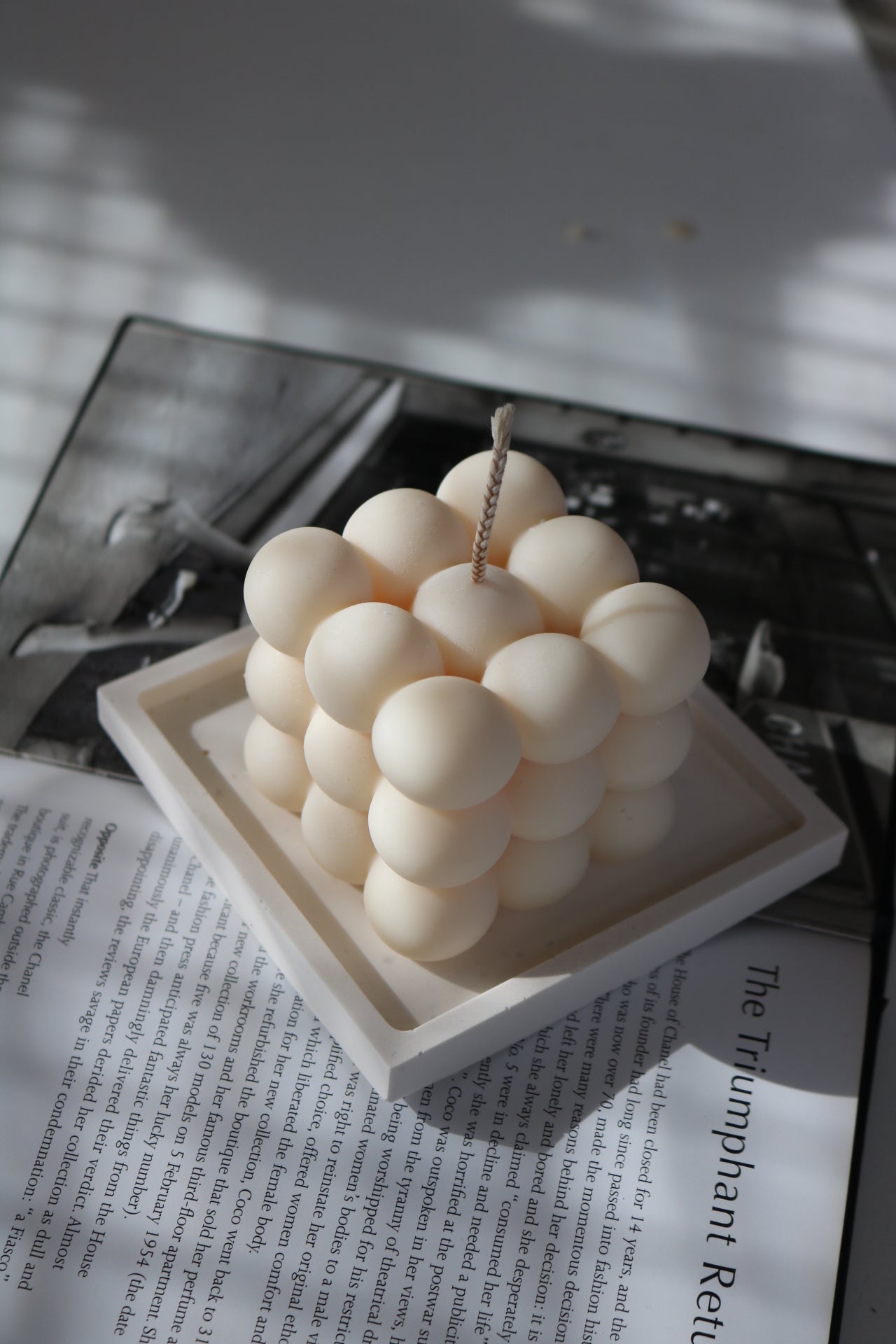 A square decorative candle tray in natural and white colors, showcasing its unique hand-made finish and elegant design.