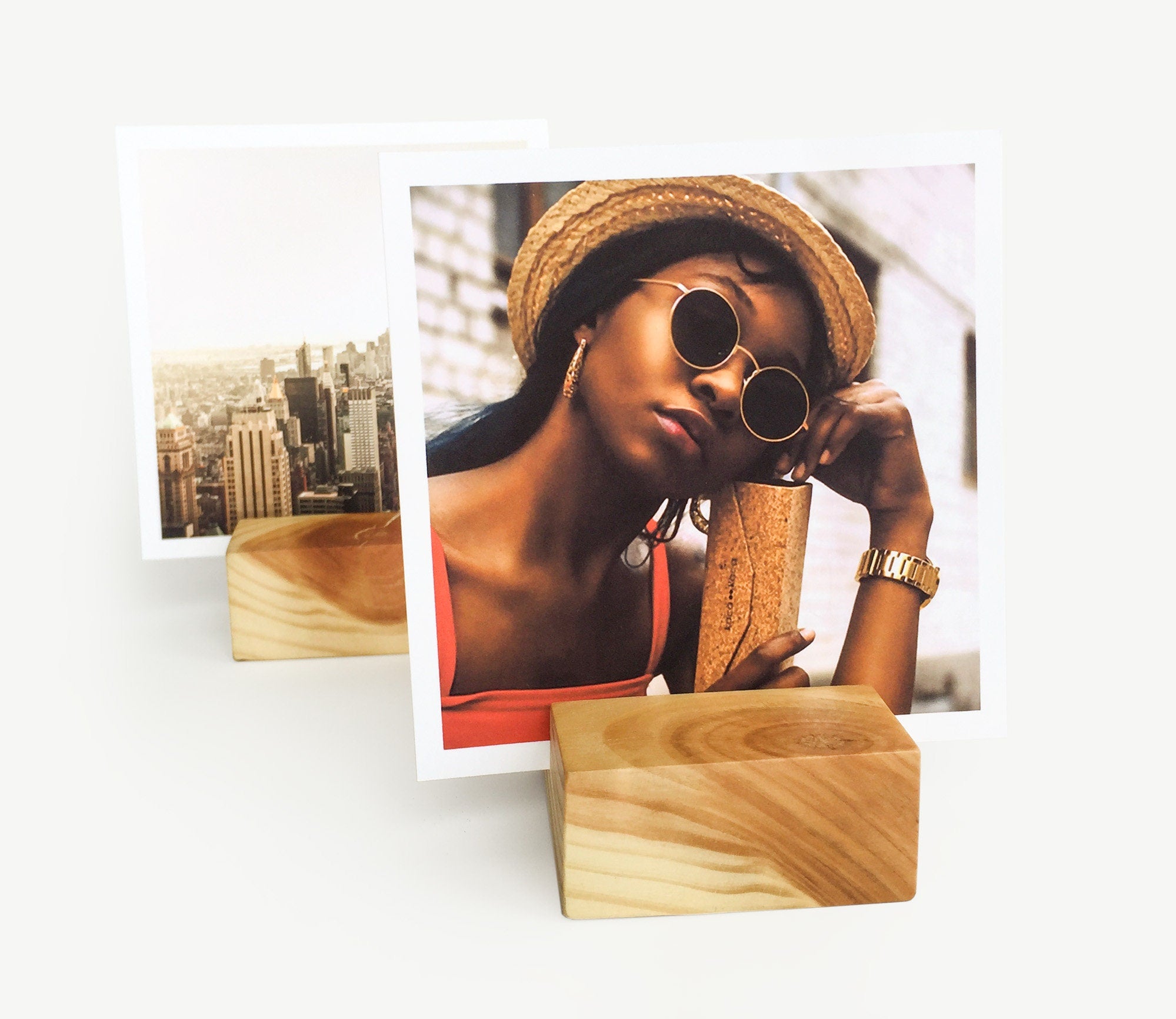 A handcrafted square wood card holder displaying various small art prints and photos, showcasing its eco-friendly design and natural finish.