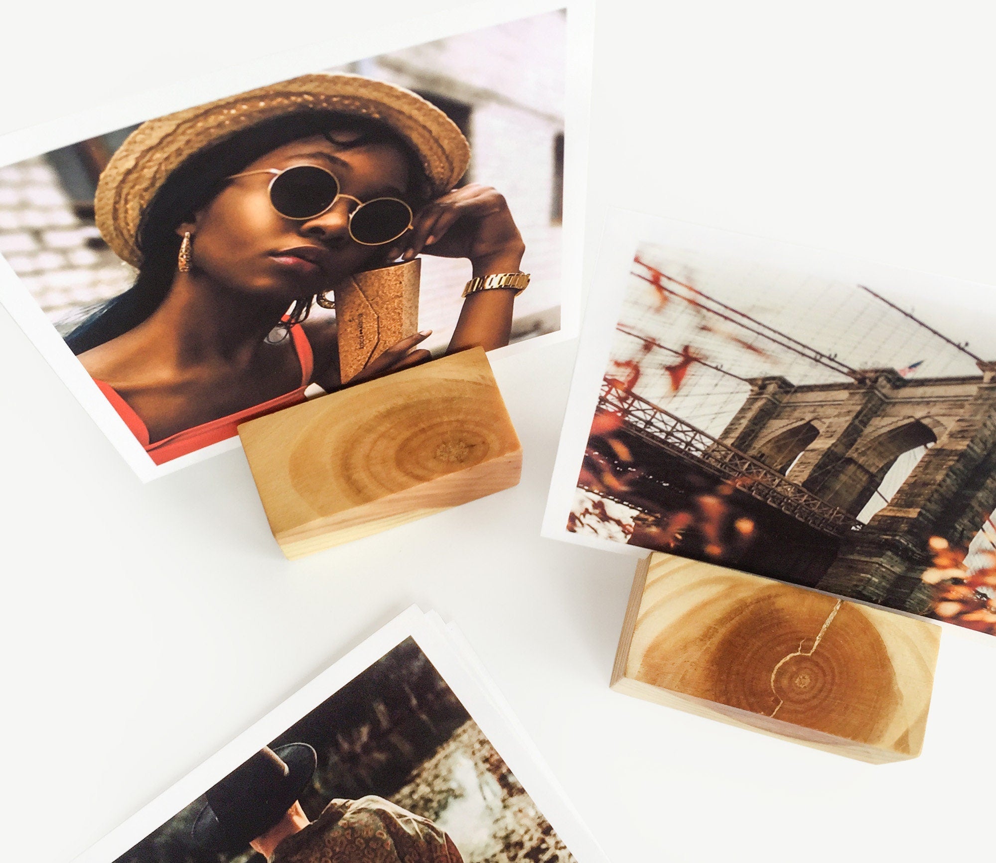 A handcrafted square wood card holder displaying various small art prints and photos, showcasing its eco-friendly design and natural finish.