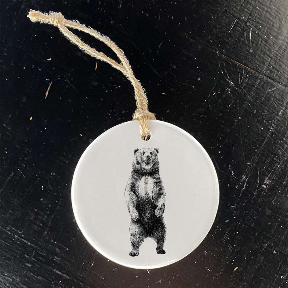 A beautifully crafted porcelain ornament featuring a Standing Bear sketch, showcasing vibrant colors and a glossy finish.