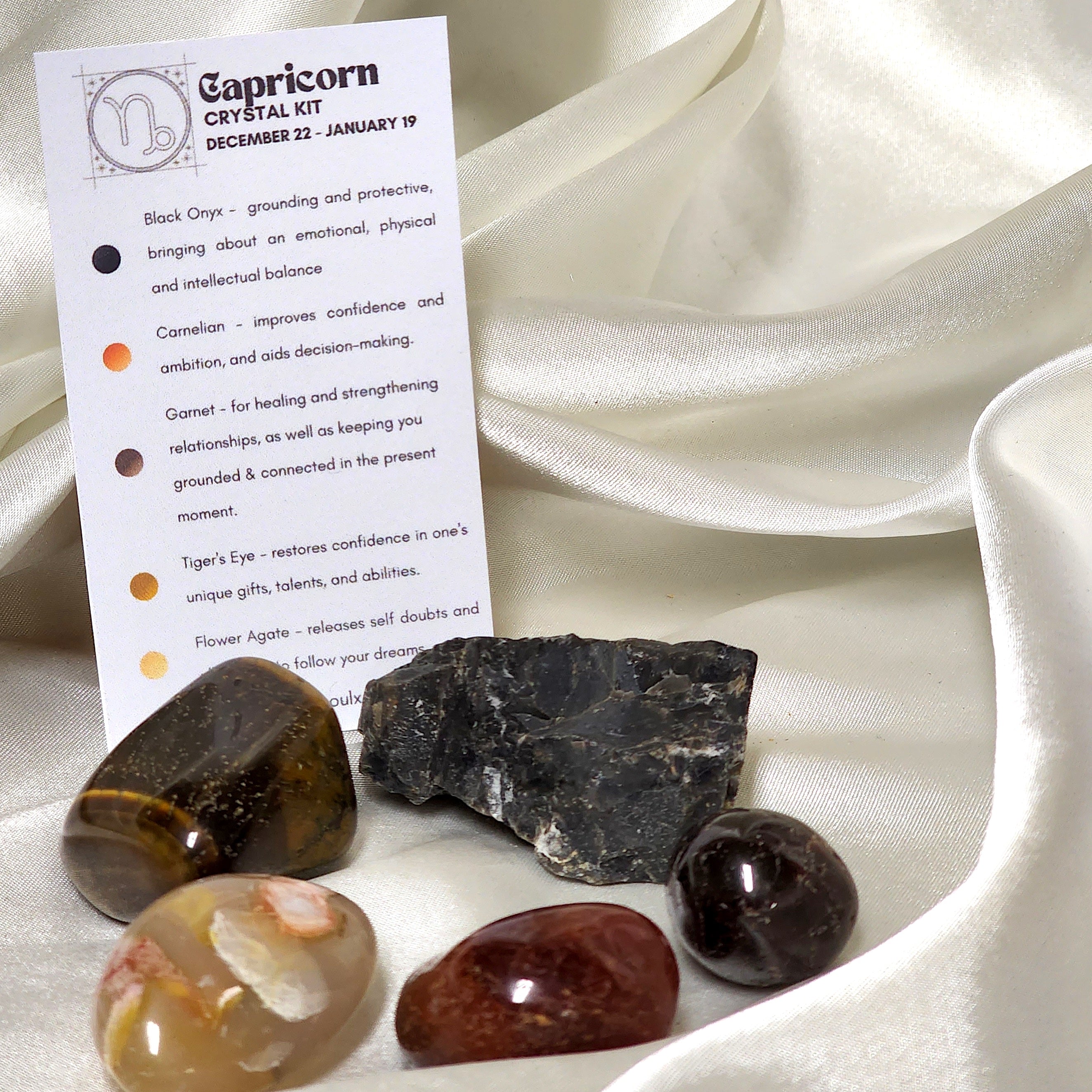 Star Sign Crystal Healing Kit for Capricorn featuring Flower Agate, Tiger's Eye, Garnet, Black Onyx, and Carnelian in an elegant display.