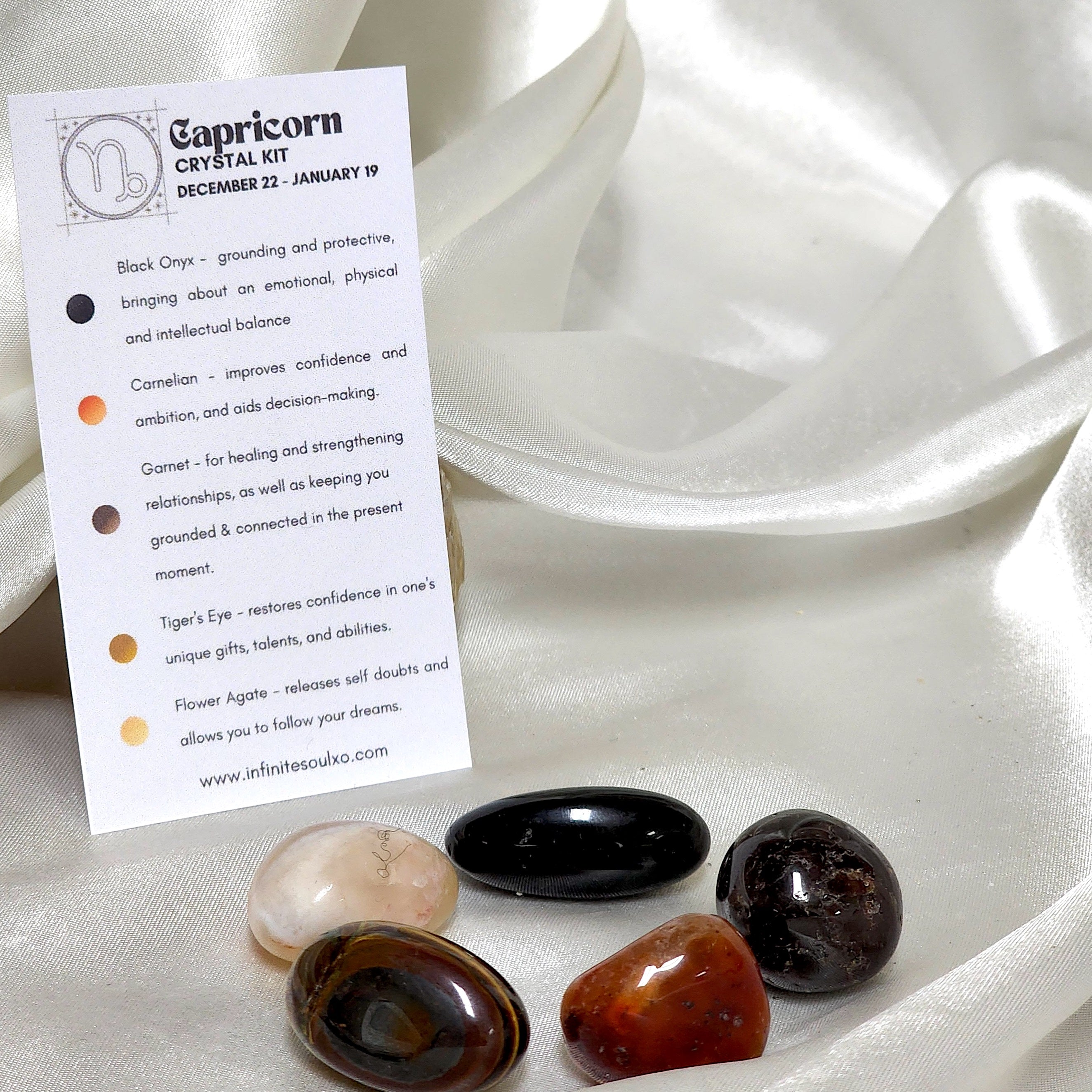 Star Sign Crystal Healing Kit for Capricorn featuring Flower Agate, Tiger's Eye, Garnet, Black Onyx, and Carnelian in an elegant display.