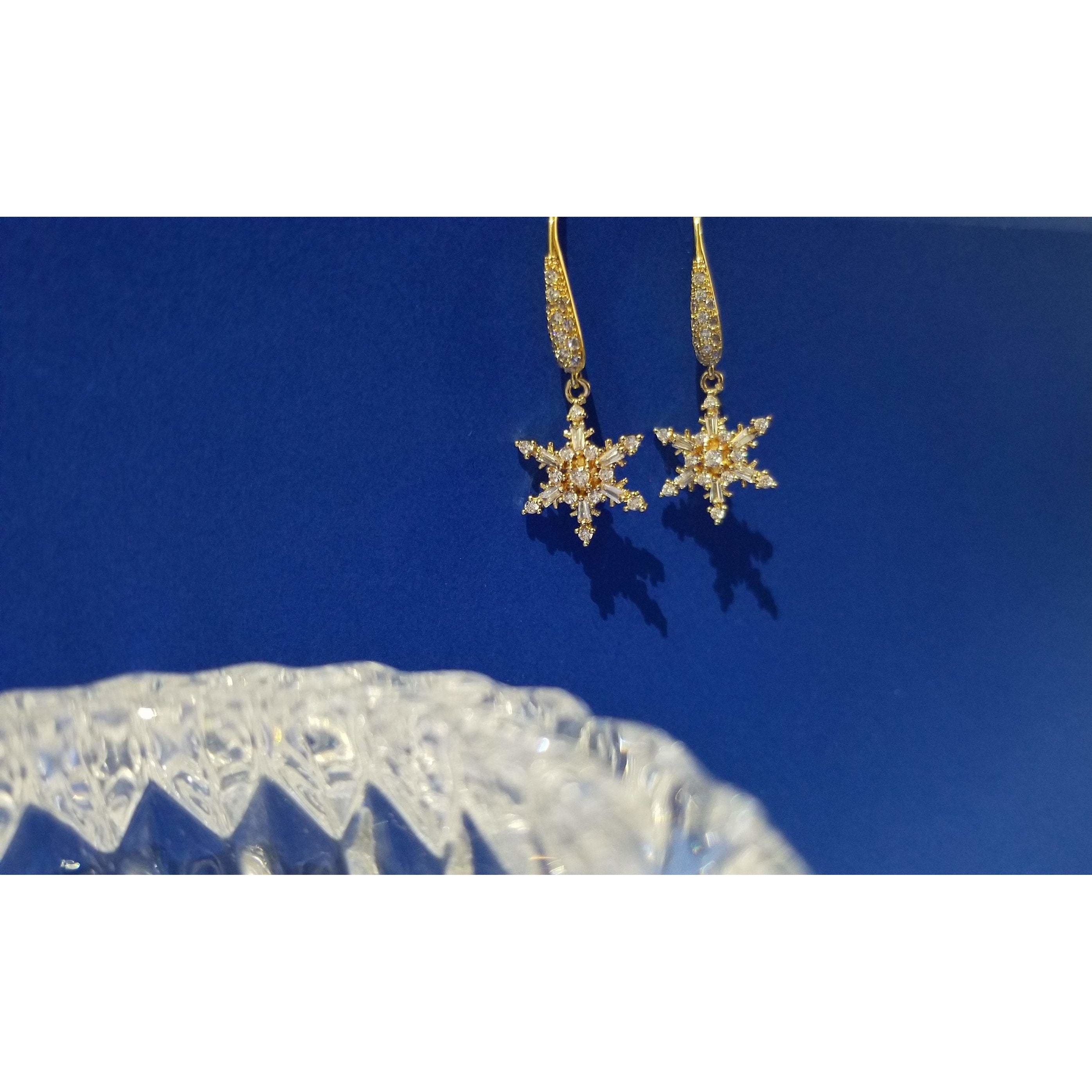 Elegant gold plated drop earrings featuring intricate snowflake design with sparkling cubic zirconia stones.