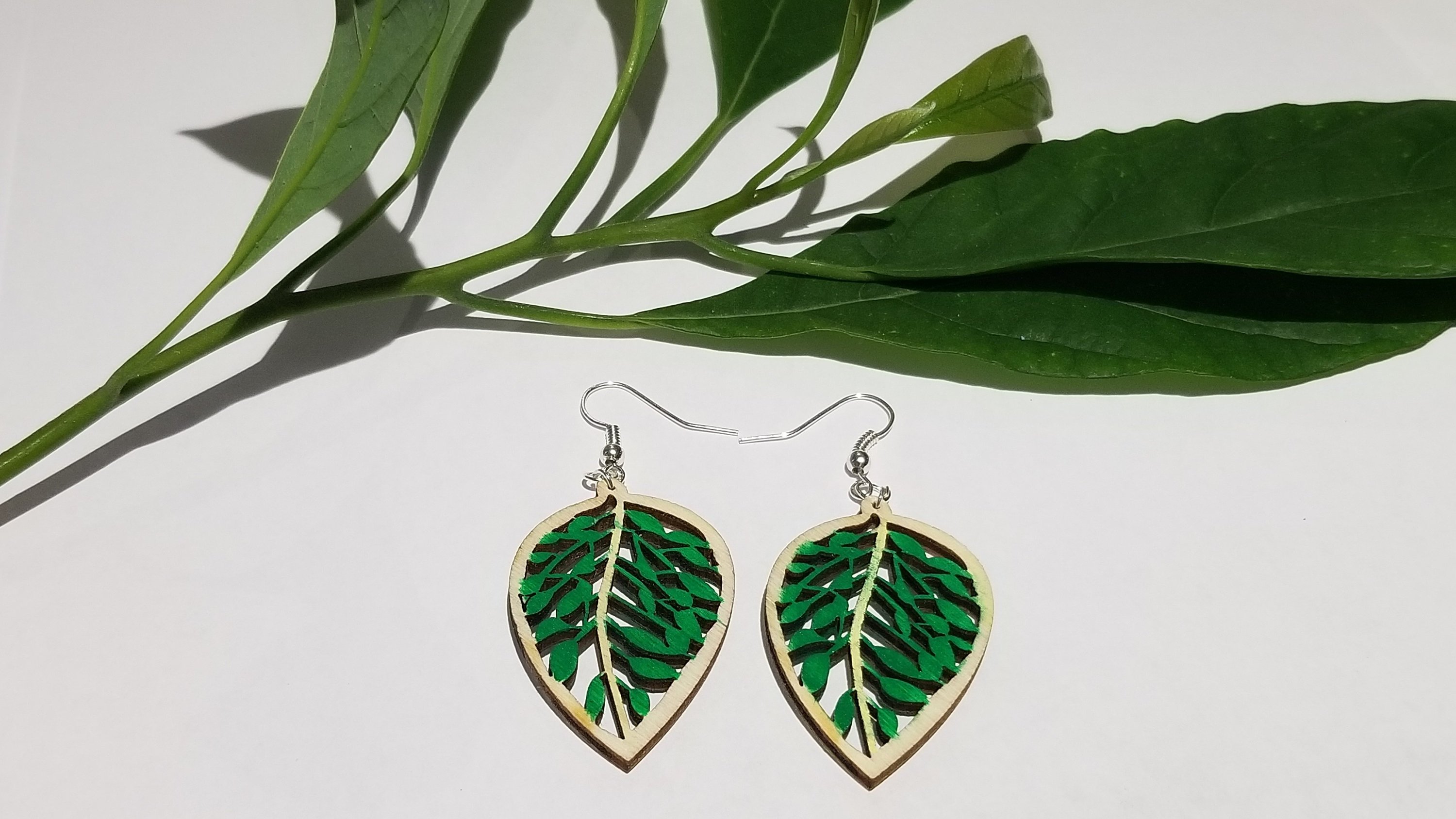 Handmade wooden leaf earrings featuring a delicate design with stainless steel ear wire, showcasing natural wood grain and elegance.