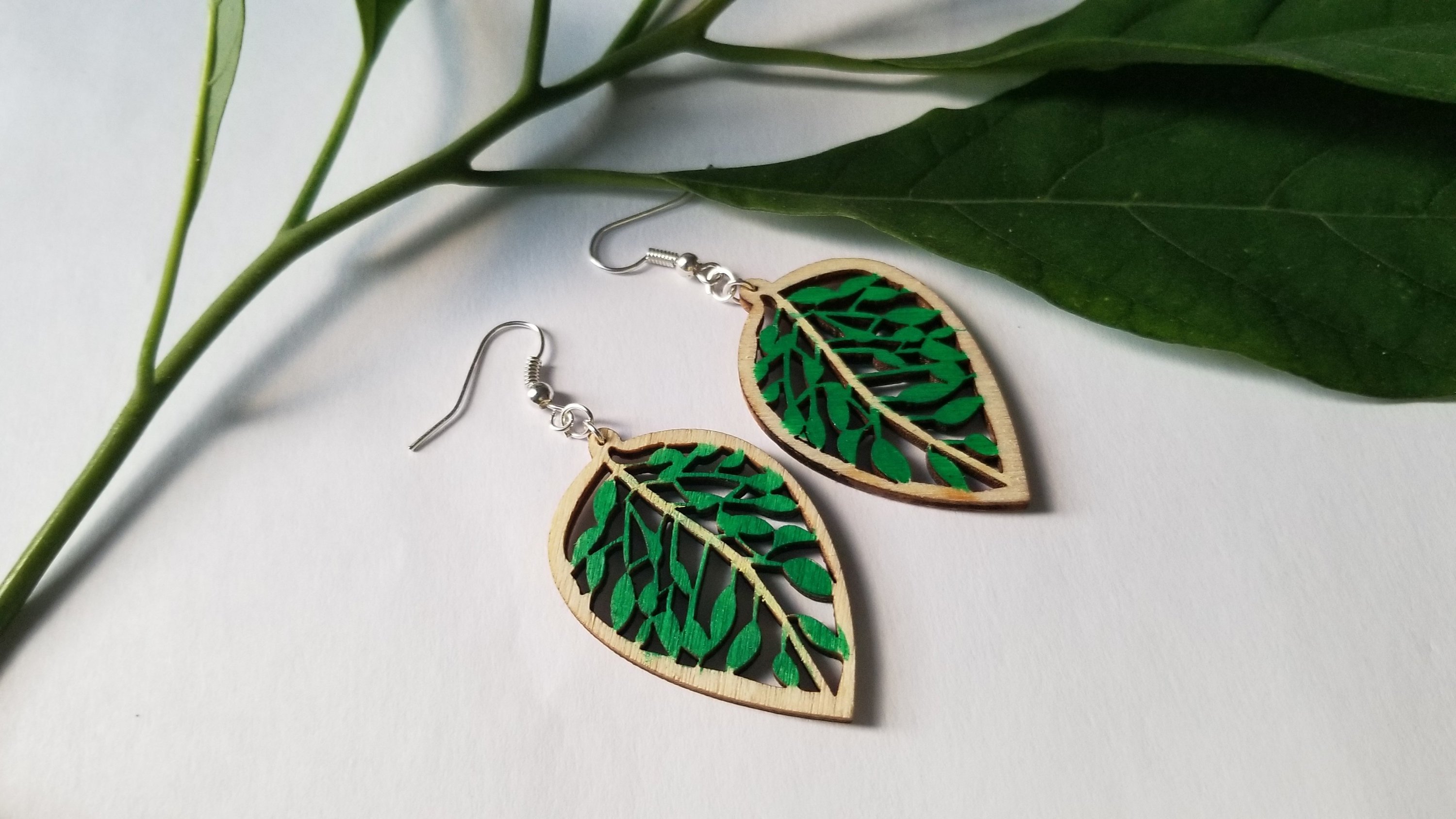 Handmade wooden leaf earrings featuring a delicate design with stainless steel ear wire, showcasing natural wood grain and elegance.