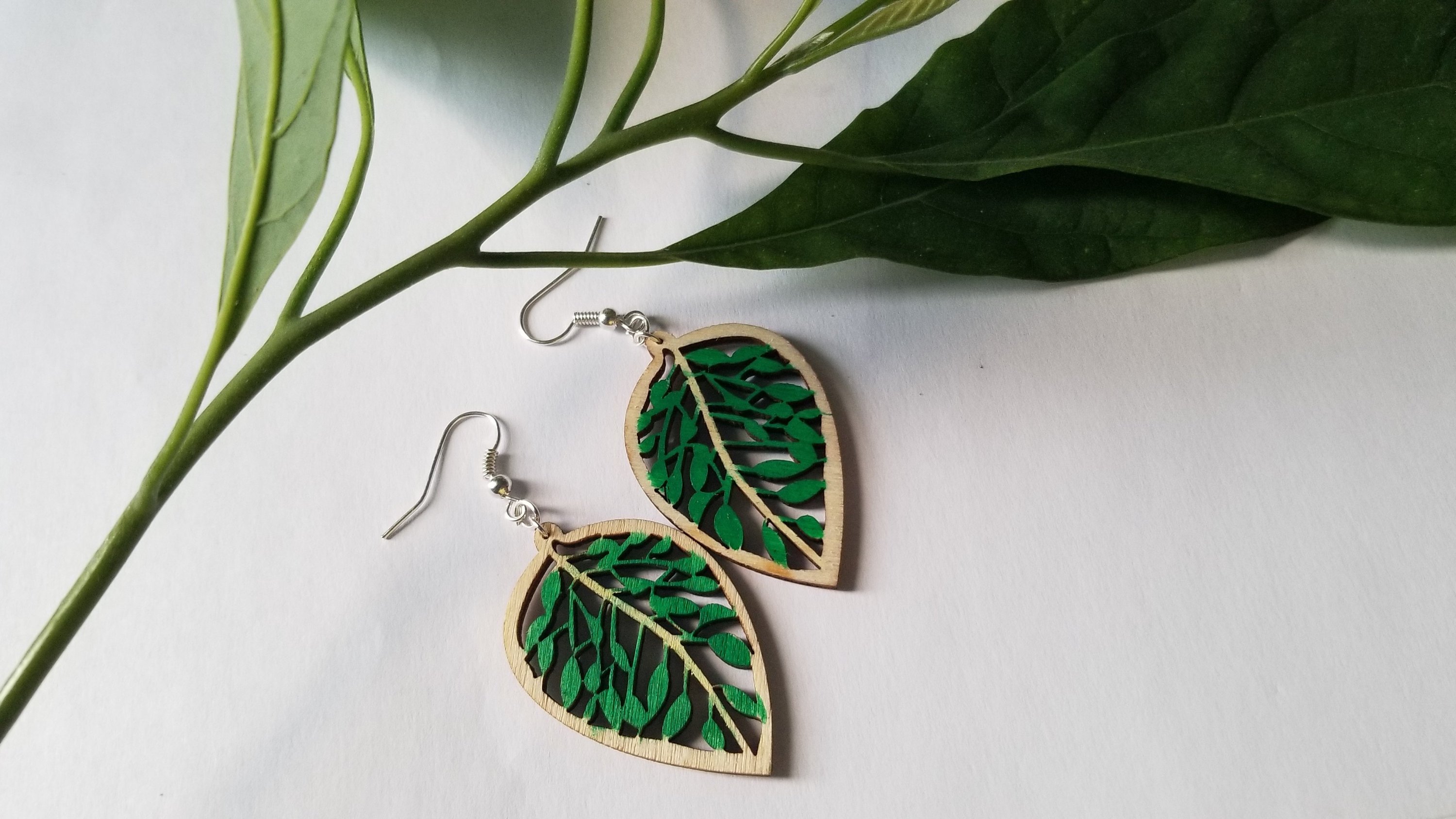 Handmade wooden leaf earrings featuring a delicate design with stainless steel ear wire, showcasing natural wood grain and elegance.