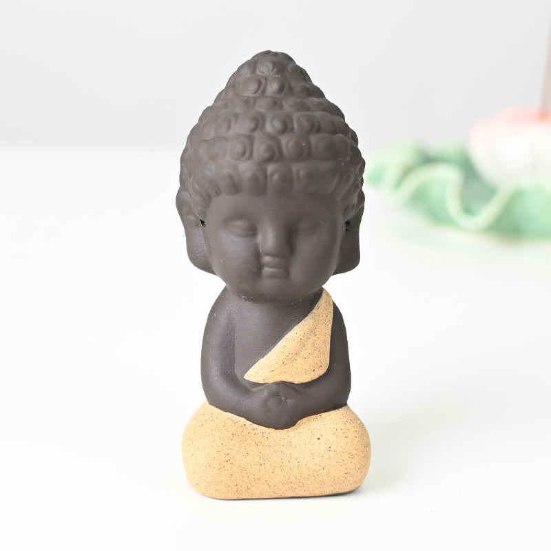 Statue en céramique représentant un moine en méditation, habillé de jaune, exécutant le dhyana mudra.