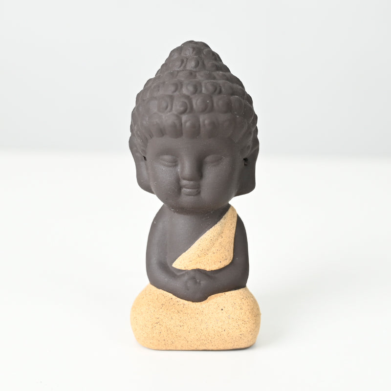 Statue en céramique représentant un moine en méditation, habillé de jaune, exécutant le dhyana mudra.