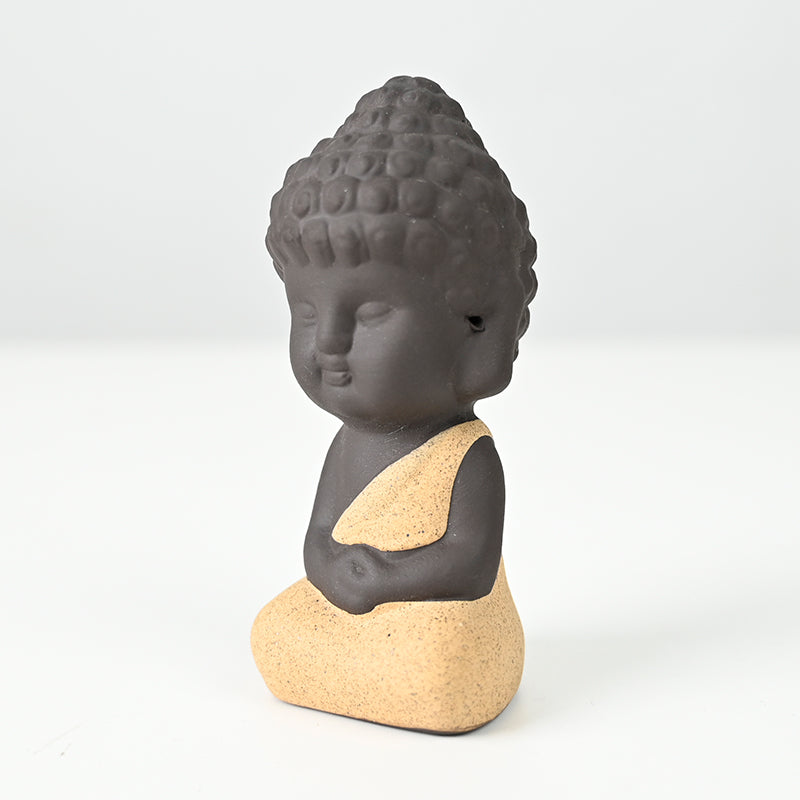 Statue en céramique représentant un moine en méditation, habillé de jaune, exécutant le dhyana mudra.