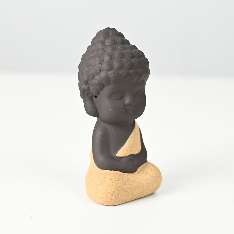 Statue en céramique représentant un moine en méditation, habillé de jaune, exécutant le dhyana mudra.